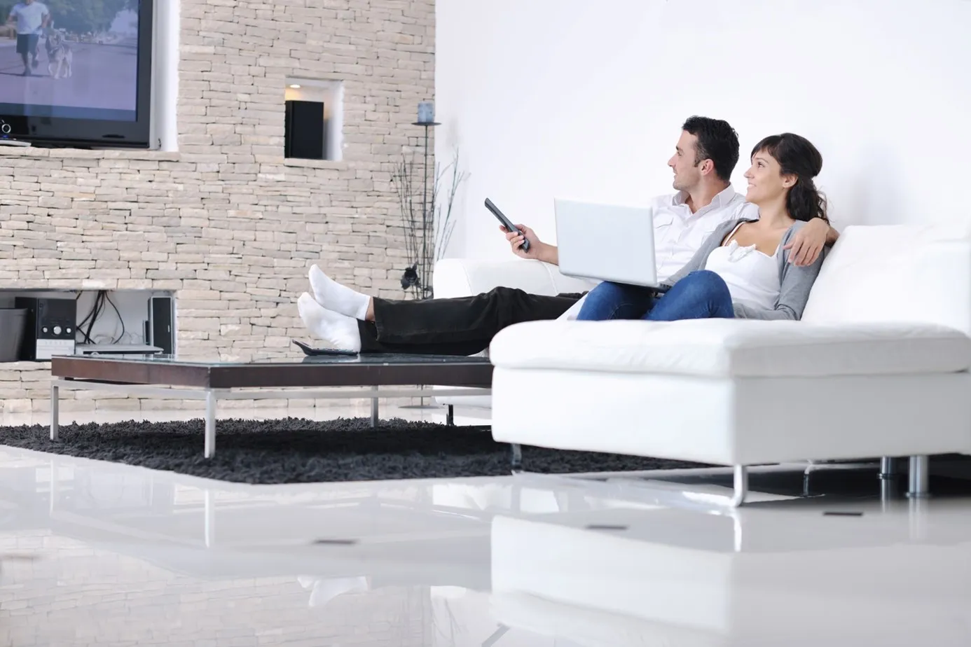 Ein Paar sitzt auf einem Sofa in einem von SANHA® geplanten Wohnheizsystem