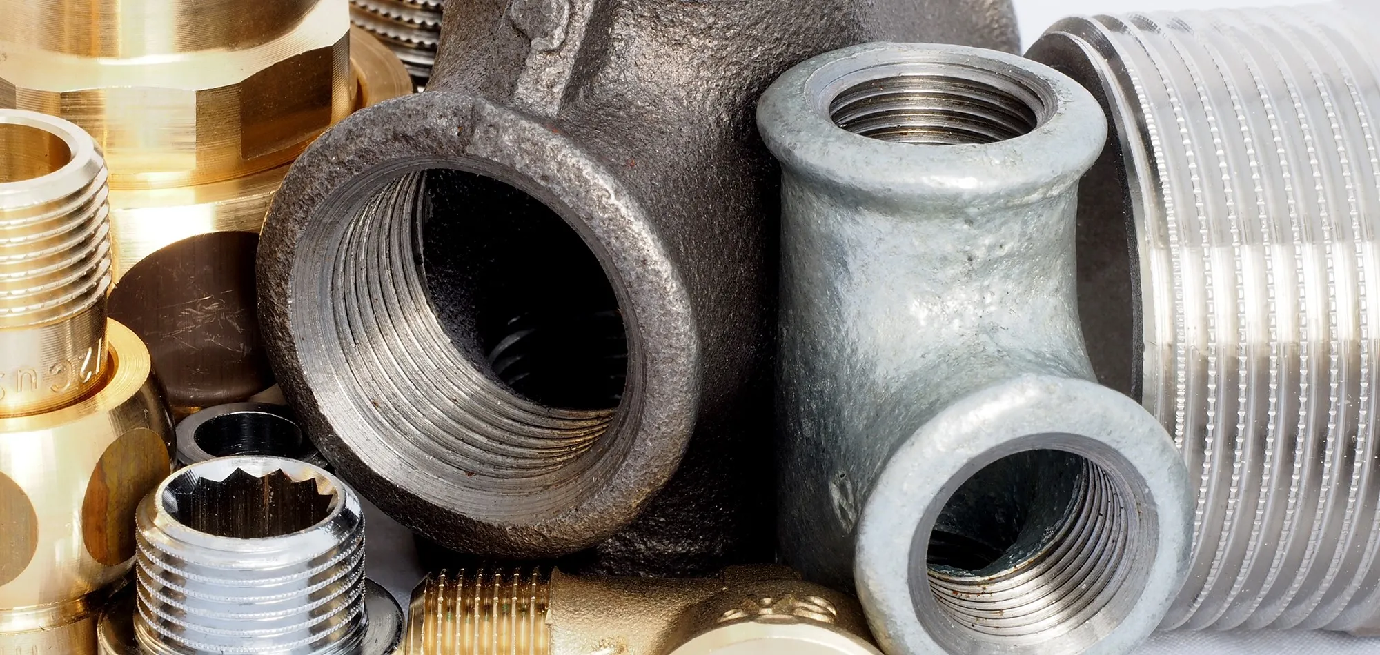 Verschiedene Temperguss- und Messing-Gewindefittings von SANHA® werden miteinander aufgestellt