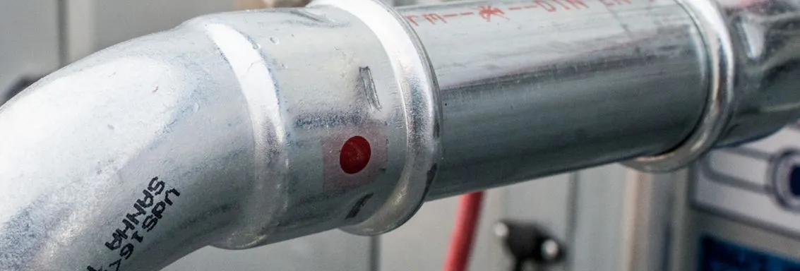 Banner, der ein Rohrsystem der Marke SANHA® Therm Industry abbildet