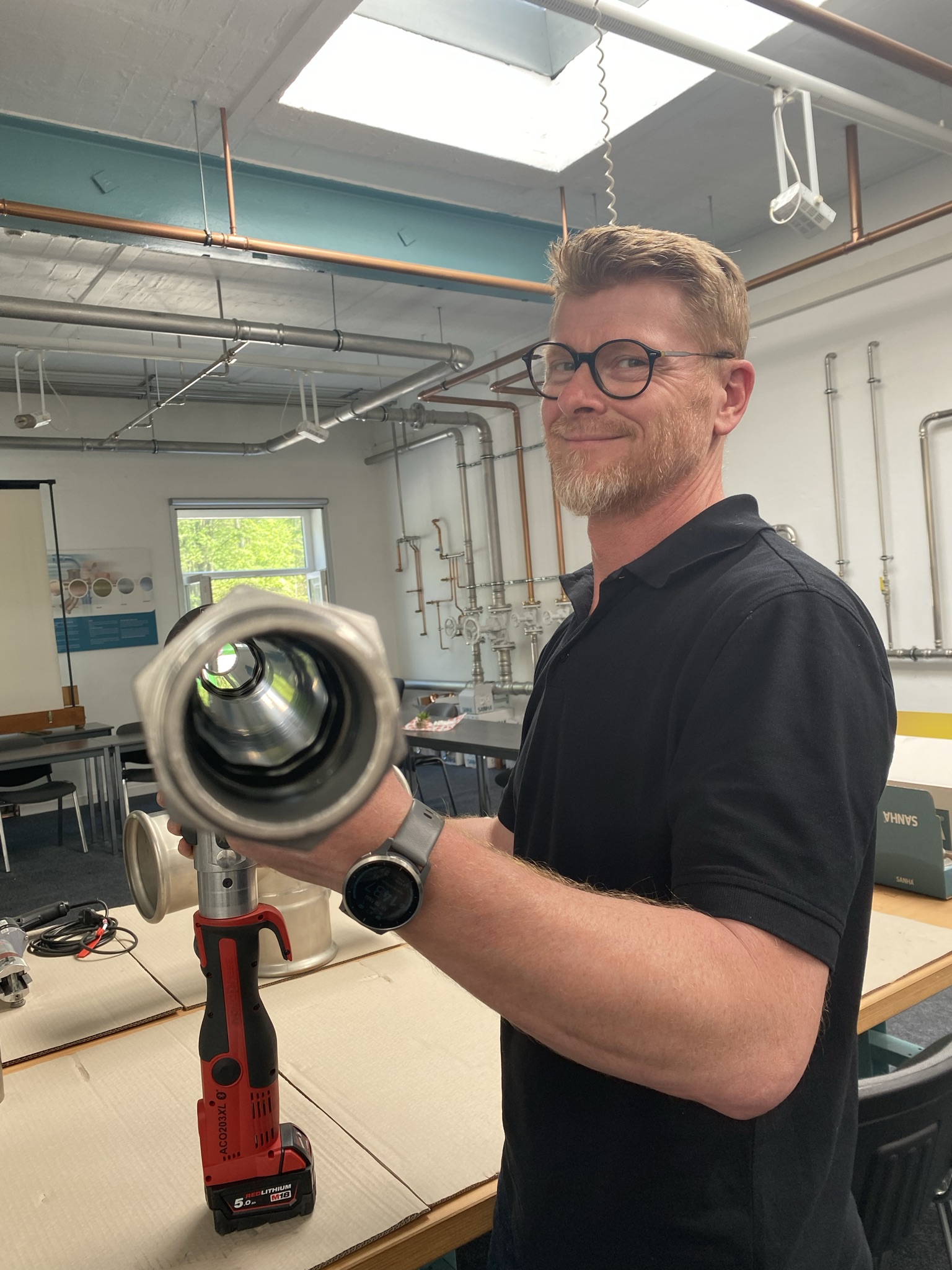 Von SANHA® hergestelltes, großes Pressfitting wird von Mitarbeiter präsentiert
